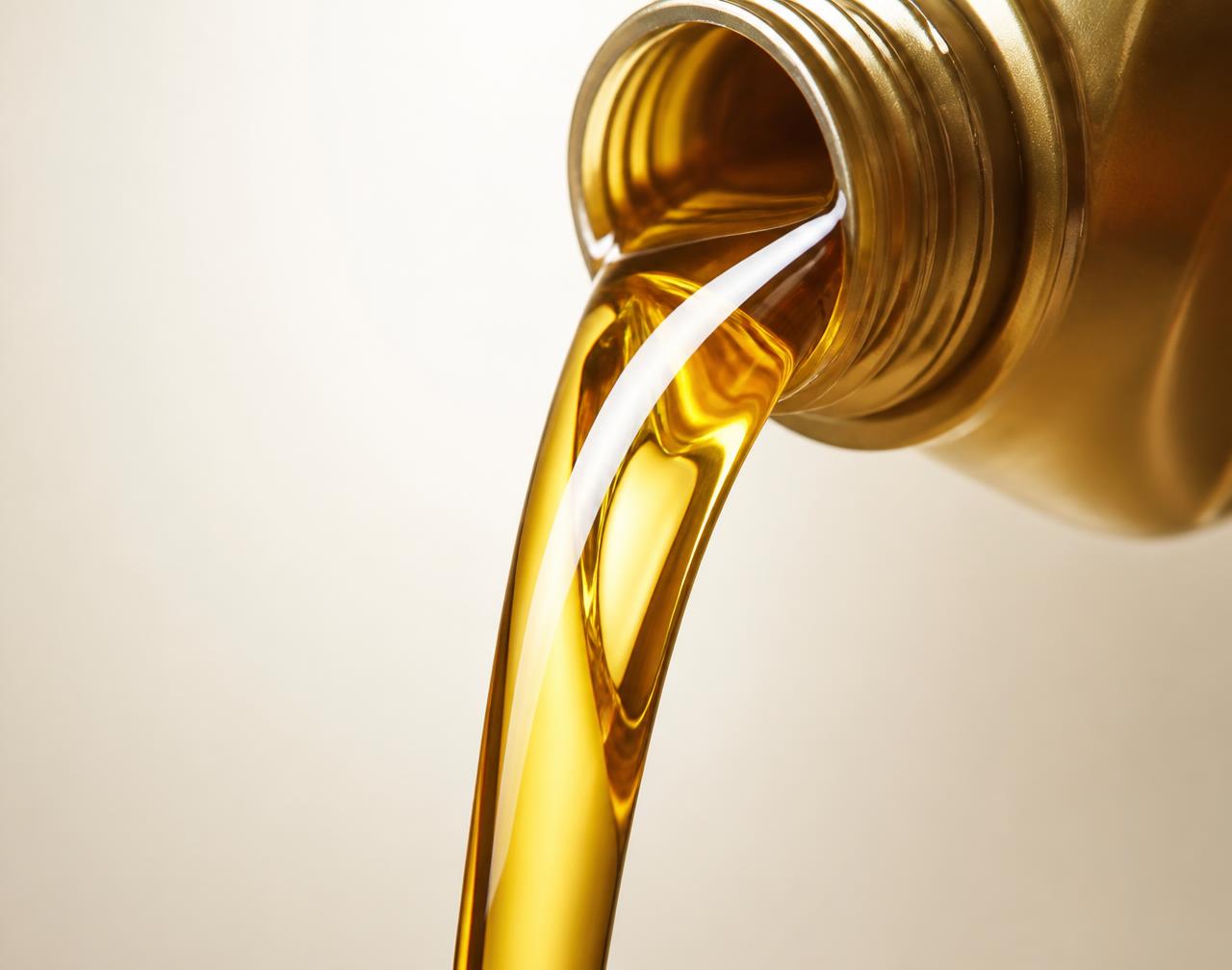 Premium golden lubricant being poured from a container